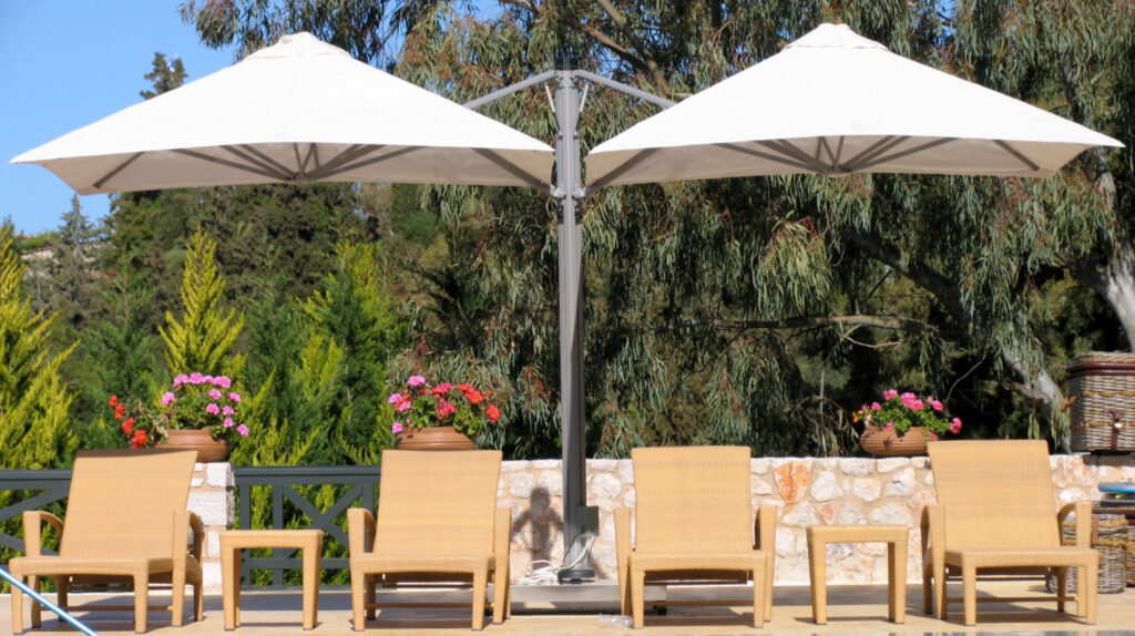p6 square duo umbrella providing shade to four poolside chairs