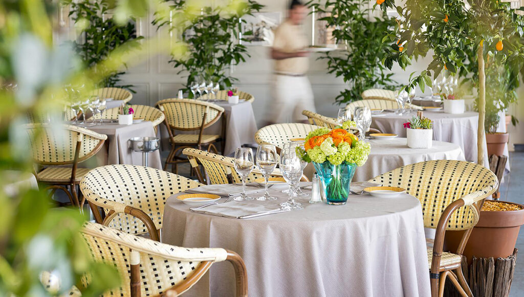 french bistro armchairs staged around tables set with glasses and flowers